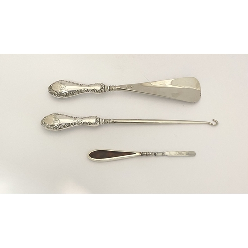 62 - AN EDWARDIAN SILVER SHOEHORN, BUTTON HOOK & CUTICLE PUSHER, the shoe horn and button hook engraved ‘... 