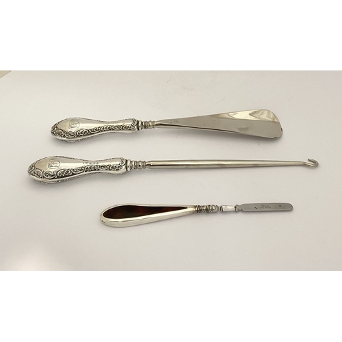 62 - AN EDWARDIAN SILVER SHOEHORN, BUTTON HOOK & CUTICLE PUSHER, the shoe horn and button hook engraved ‘... 