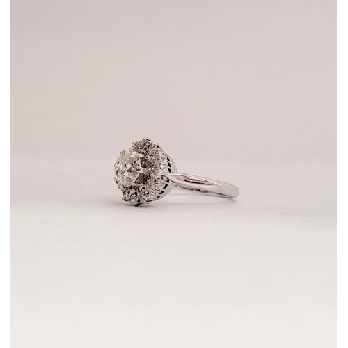 101 - A VERY FINE 18CT WHITE GOLD DIAMOND CLUSTER RING, with a large raised central round diamond, surroun... 