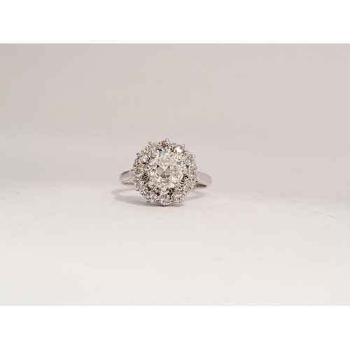 101 - A VERY FINE 18CT WHITE GOLD DIAMOND CLUSTER RING, with a large raised central round diamond, surroun... 