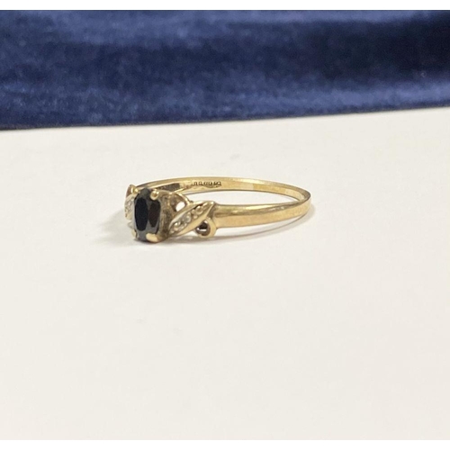 105 - A NICE 9CT YELLOW GOLD SAPPHIRE & DIAMOND CROSS OVER RING, with central oval cut sapphire in four pr... 