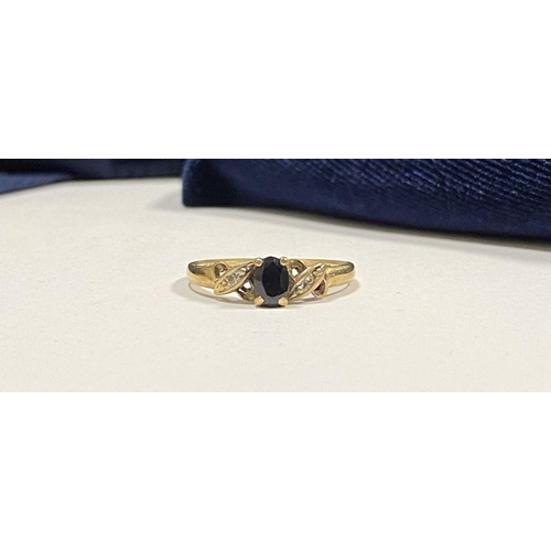 105 - A NICE 9CT YELLOW GOLD SAPPHIRE & DIAMOND CROSS OVER RING, with central oval cut sapphire in four pr... 