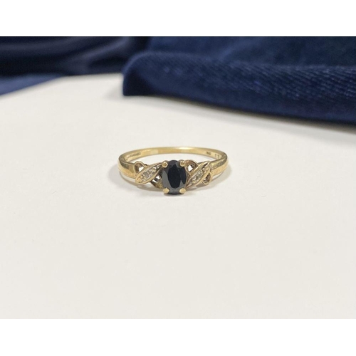 105 - A NICE 9CT YELLOW GOLD SAPPHIRE & DIAMOND CROSS OVER RING, with central oval cut sapphire in four pr... 