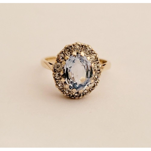 109 - A PRETTY 9CT YELLOW GOLD AQUAMARINE CLUSTER RING, the central oval shaped pale blue stone sits insid... 