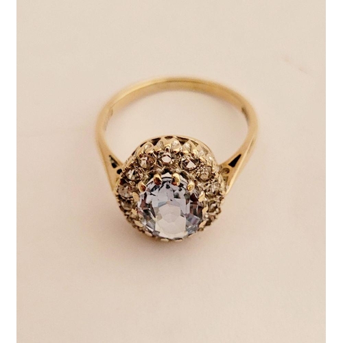 109 - A PRETTY 9CT YELLOW GOLD AQUAMARINE CLUSTER RING, the central oval shaped pale blue stone sits insid... 