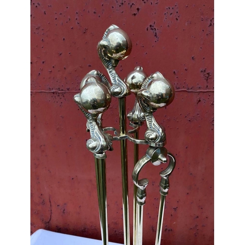 112 - A GOOD SET OF FOUR POLISHED BRASS FIRE IRONS ON STAND, to include shovel, brush, tongs and poker, al... 