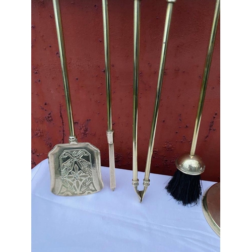 112 - A GOOD SET OF FOUR POLISHED BRASS FIRE IRONS ON STAND, to include shovel, brush, tongs and poker, al... 