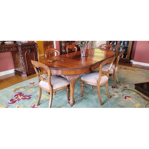 130 - A LARGE EXTENDABLE DINING TABLE, with gadrooned edging, raised on four carved cabriole shaped legs w... 