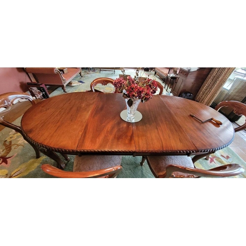 130 - A LARGE EXTENDABLE DINING TABLE, with gadrooned edging, raised on four carved cabriole shaped legs w... 