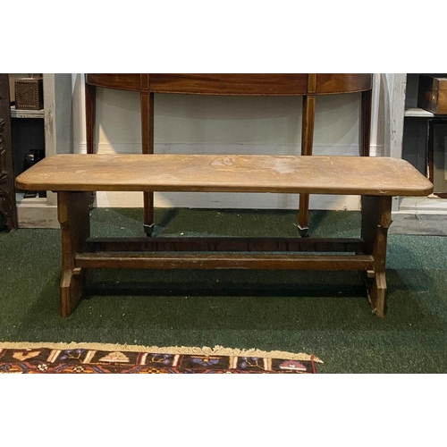 156 - A LONG HARDWOOD BENCH, the rectangular top with canted corners, with shaped supports joining a doubl... 