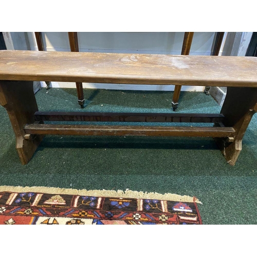 156 - A LONG HARDWOOD BENCH, the rectangular top with canted corners, with shaped supports joining a doubl... 