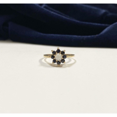 157 - A PRETTY 9CT YELLOW GOLD OPAL & SAPPHIRE CLUSTER RING, with central claw set round cut opal surround... 