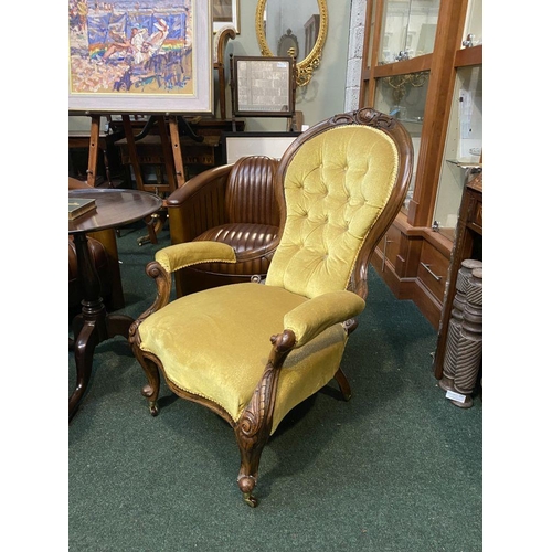 162 - A VICTORIAN MAHOGANY UPHOLSTERED BUTTON BACK ARMCHAIR, the mahogany frame with carved crest to top, ... 