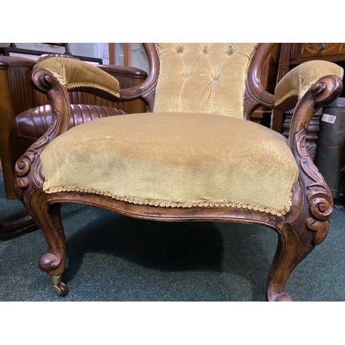 162 - A VICTORIAN MAHOGANY UPHOLSTERED BUTTON BACK ARMCHAIR, the mahogany frame with carved crest to top, ... 