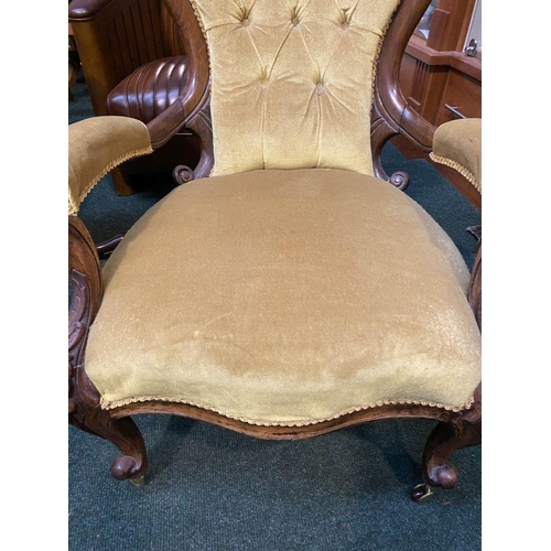 162 - A VICTORIAN MAHOGANY UPHOLSTERED BUTTON BACK ARMCHAIR, the mahogany frame with carved crest to top, ... 