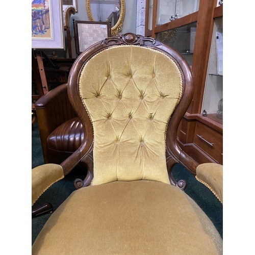 162 - A VICTORIAN MAHOGANY UPHOLSTERED BUTTON BACK ARMCHAIR, the mahogany frame with carved crest to top, ... 