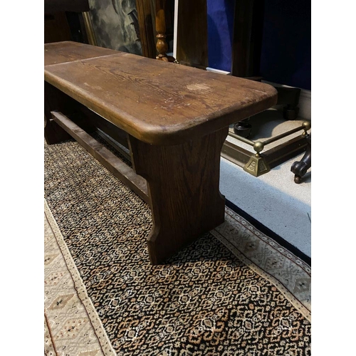 179 - A LONG HARDWOOD BENCH, the rectangular top with canted corners, with shaped supports joining a doubl... 