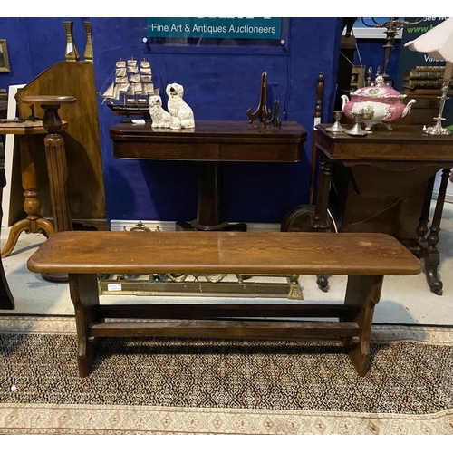 179 - A LONG HARDWOOD BENCH, the rectangular top with canted corners, with shaped supports joining a doubl... 