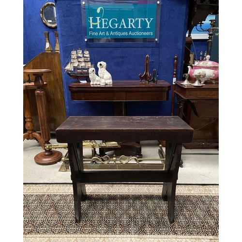 181 - A DARK STAINED HARDWOOD STOOL/BENCH, with shaped supports joined by a cross stretcher. The supports ... 