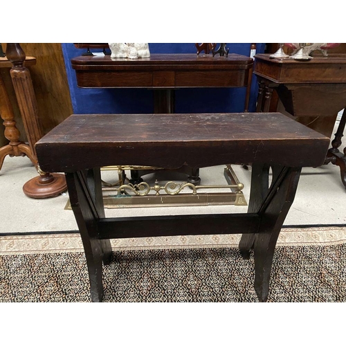 181 - A DARK STAINED HARDWOOD STOOL/BENCH, with shaped supports joined by a cross stretcher. The supports ... 