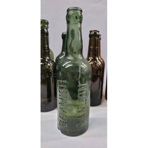 199 - A GREAT COLLECTION OF VINTAGE COLOURED GLASS BOTTLES, includes 5 West Cork Bottling bottles, a Cade’... 