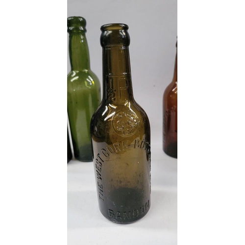 199 - A GREAT COLLECTION OF VINTAGE COLOURED GLASS BOTTLES, includes 5 West Cork Bottling bottles, a Cade’... 