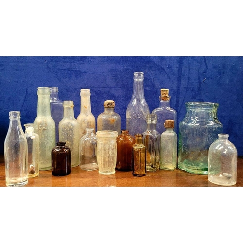 216 - A LARGE COLLECTION OF ANTIQUE IRISH GLASS JARS/BOTTLES, includes mostly clear glass with a few brown... 