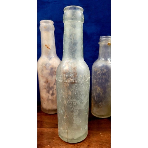 216 - A LARGE COLLECTION OF ANTIQUE IRISH GLASS JARS/BOTTLES, includes mostly clear glass with a few brown... 