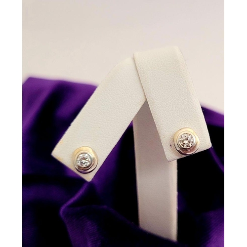 26 - A LOVELY PAIR OF BEZEL SET DIAMOND STUD EARRINGS, with light gold frames. Perfect for any occasion d... 