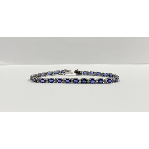 43 - AN EXCEPTIONAL 18CT WHITE GOLD SAPPHIRE & DIAMOND TENNIS BRACELET, with 26 oval cut sapphires separa... 