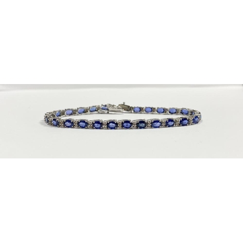 43 - AN EXCEPTIONAL 18CT WHITE GOLD SAPPHIRE & DIAMOND TENNIS BRACELET, with 26 oval cut sapphires separa... 