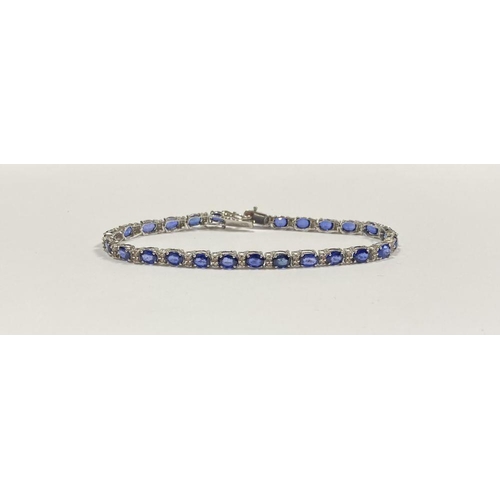 43 - AN EXCEPTIONAL 18CT WHITE GOLD SAPPHIRE & DIAMOND TENNIS BRACELET, with 26 oval cut sapphires separa... 