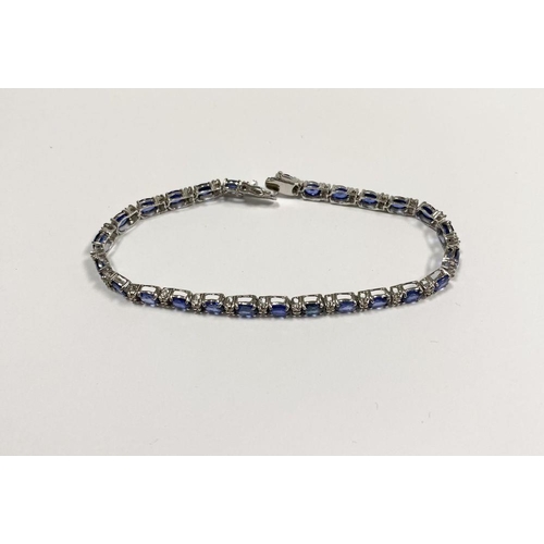 43 - AN EXCEPTIONAL 18CT WHITE GOLD SAPPHIRE & DIAMOND TENNIS BRACELET, with 26 oval cut sapphires separa... 