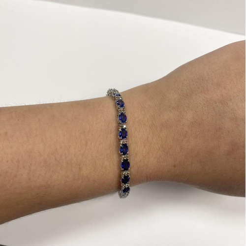 43 - AN EXCEPTIONAL 18CT WHITE GOLD SAPPHIRE & DIAMOND TENNIS BRACELET, with 26 oval cut sapphires separa... 