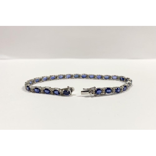 43 - AN EXCEPTIONAL 18CT WHITE GOLD SAPPHIRE & DIAMOND TENNIS BRACELET, with 26 oval cut sapphires separa... 