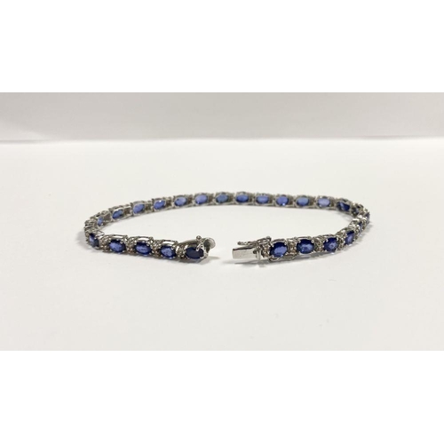 43 - AN EXCEPTIONAL 18CT WHITE GOLD SAPPHIRE & DIAMOND TENNIS BRACELET, with 26 oval cut sapphires separa... 