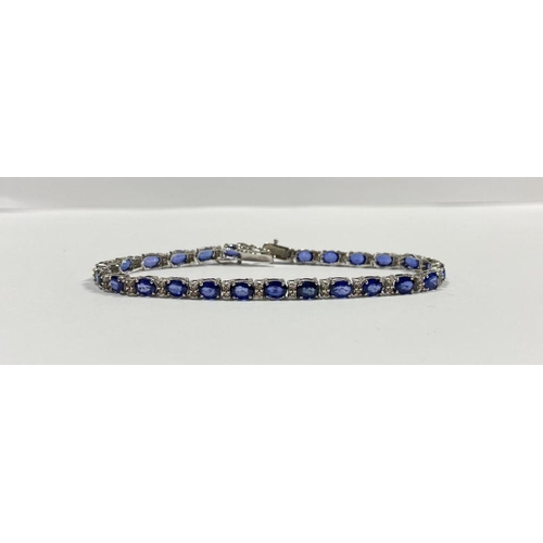 43 - AN EXCEPTIONAL 18CT WHITE GOLD SAPPHIRE & DIAMOND TENNIS BRACELET, with 26 oval cut sapphires separa... 