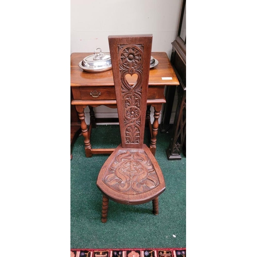 48 - A HAND CARVED ARTS ‘N’ CRAFTS OAK SPINNING CHAIR, with a tall tapered carved panel back, showing flo... 