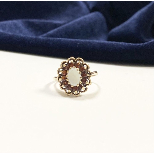 51 - AN ANTIQUE 9CT YELLOW GOLD OPAL & GARNET CLUSTER RING, with central oval cut claw set opal surrounde... 