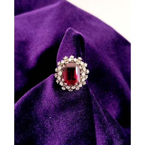 82 - A SUNBURST STYLE COCKTAIL RING: GARNET & DIAMOND BY PIAGET, a large central oval shaped garnet sits ... 