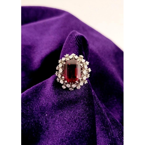 82 - A SUNBURST STYLE COCKTAIL RING: GARNET & DIAMOND BY PIAGET, a large central oval shaped garnet sits ... 