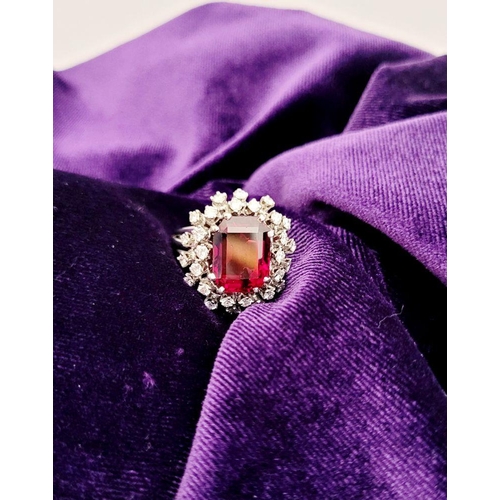 82 - A SUNBURST STYLE COCKTAIL RING: GARNET & DIAMOND BY PIAGET, a large central oval shaped garnet sits ... 