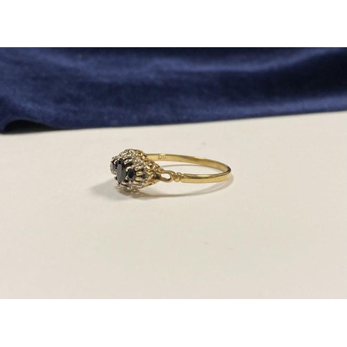 98 - AN ORNATE 9CT GOLD SAPPHIRE AND DIAMOND THREE STONE CLUSTER RING, with central oval cut sapphire fla... 