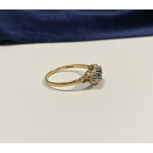 98 - AN ORNATE 9CT GOLD SAPPHIRE AND DIAMOND THREE STONE CLUSTER RING, with central oval cut sapphire fla... 