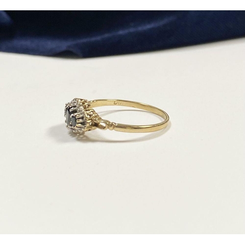 98 - AN ORNATE 9CT GOLD SAPPHIRE AND DIAMOND THREE STONE CLUSTER RING, with central oval cut sapphire fla... 