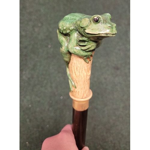 251 - A WHIMSICAL GREEN FROG HANDLED WALKING CANE / STICK, the stick features a hand-coloured green frog p... 