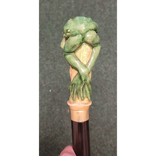 251 - A WHIMSICAL GREEN FROG HANDLED WALKING CANE / STICK, the stick features a hand-coloured green frog p... 