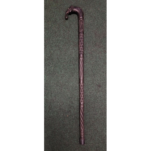 252 - AN ANTIQUE BONE INLAID EBONISED CARVED WALKING STICK, possibly Indian or Sri Lankan, the handle in t... 