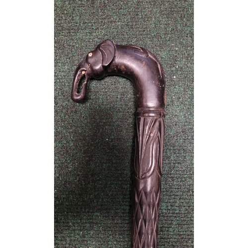 252 - AN ANTIQUE BONE INLAID EBONISED CARVED WALKING STICK, possibly Indian or Sri Lankan, the handle in t... 