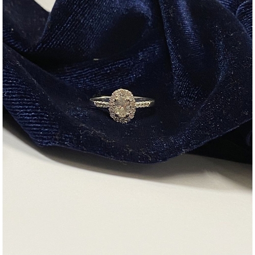 14 - A STUNNING 14CT WHITE GOLD DIAMOND CLUSTER RING, with central oval brilliant cut diamond, weight: .5... 